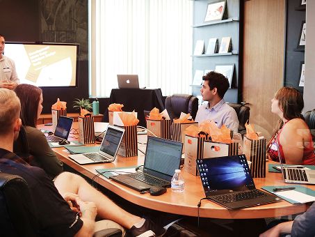 A delivery team reviewing work in progress together on their laptops